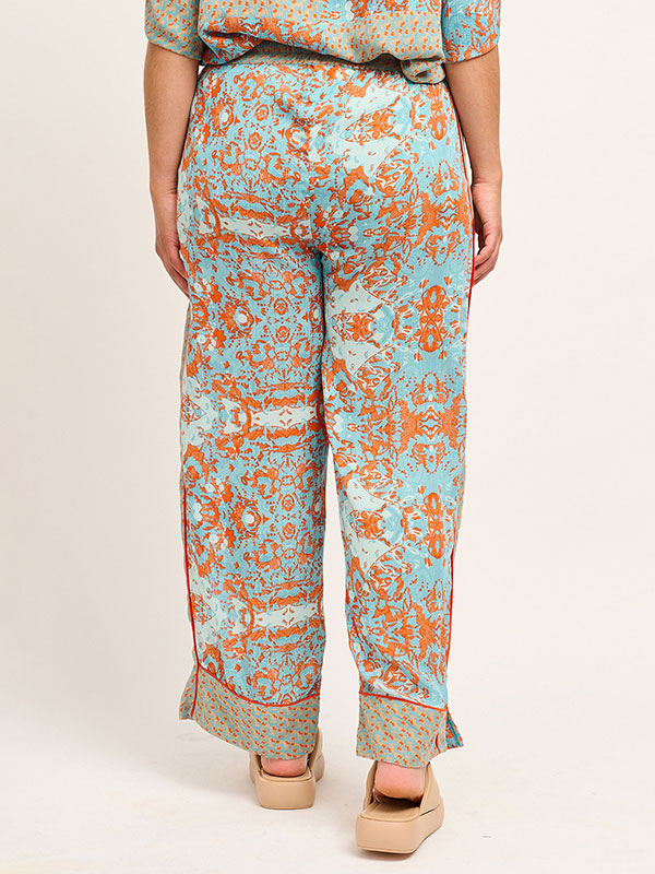 Blå bukser i crepet viskose med sand og orange mønster fra Adia
