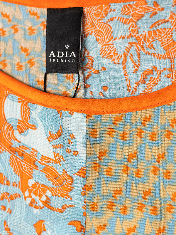 Blå bluse i crepet viskose med sand og orange mønster fra Adia