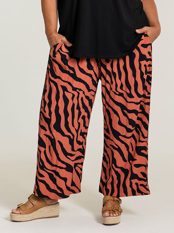 ELLY - Løse orange bukser med sort print fra Gozzip